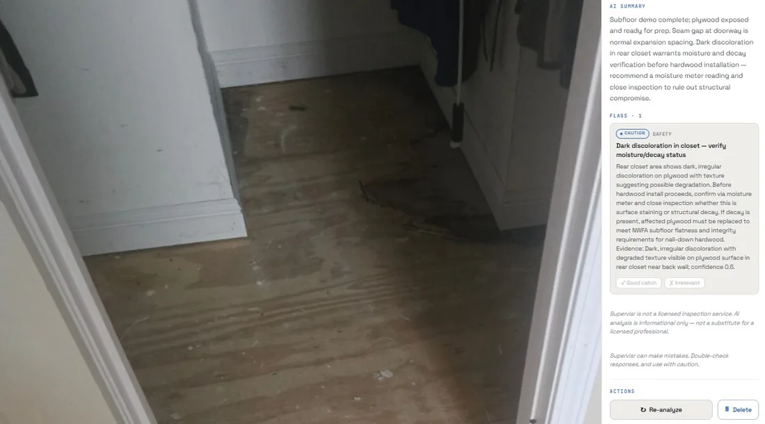 A Supervisr analysis of a plywood subfloor photo: a caution flag for dark, irregular discoloration in a rear closet, asking for a moisture-meter reading to rule out decay before hardwood installation proceeds.